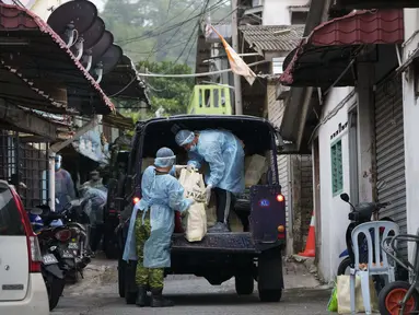 Petugas mendistribusikan kebutuhan pokok di kawasan Segambut Dalam yang berada di bawah Enhanced Movement Control Order (EMCO) akibat peningkatan drastis jumlah kasus COVID-19 yang tercatat selama 10 hari terakhir di Kuala Lumpur, Malaysia, Minggu (27/6/2021). (AP Photo/Vincent Thian)