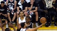 Pemain Warriors, Stephen Curry (30) berusaha memasukan bola dari kawalan LaMarcus Aldridge (12) saat bertanding pada gim pertama final Wilayah Barat playoffs NBA 2017 di Oakland, California (14/5). (Thearon W. Henderson/Getty Images/AFP)