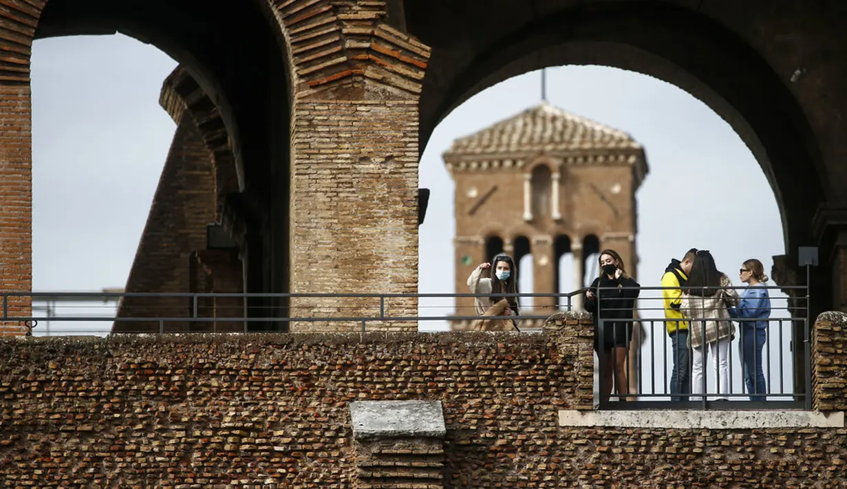 Orang-orang mengunjungi Colosseum setelah kembali dibuka, Roma, Italia, Senin (1/2/2021). Italia mencabut sebagian langkah pembatasan yang bertujuan untuk menahan penyebaran COVID-19 pada 1 Februari 2021. (Cecilia Fabiano/LaPresse via AP)