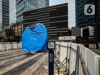 Suasana Proyek Pembangunan tugu sepeda di Jalan Jenderal Sudirman, Jakarta, Rabu (30/3/2022). Tugu yang dulu sempat boming dan digembar-gemborkan kini terlihat terhenti pengerjaannya dan hanya ditutup terpal. (Liputa6.com/Johan Tallo)