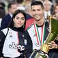 Cristiano Ronaldo bersama kekasihnya, Georgina Rodriguez, berpose dengan trofi Serie A di Stadion Allianz, Turin (19/5/2019). (AFP/Marco Bertorello)