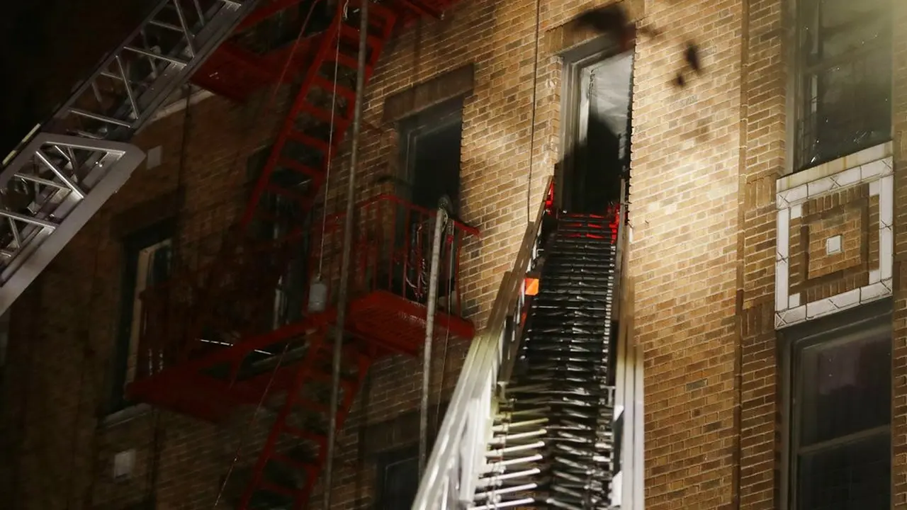 Pemadam kebakaran saat melakukan evakuasi setelah kebakaran terjadi sebuah apartemen lima lantai di Bronx, New York
