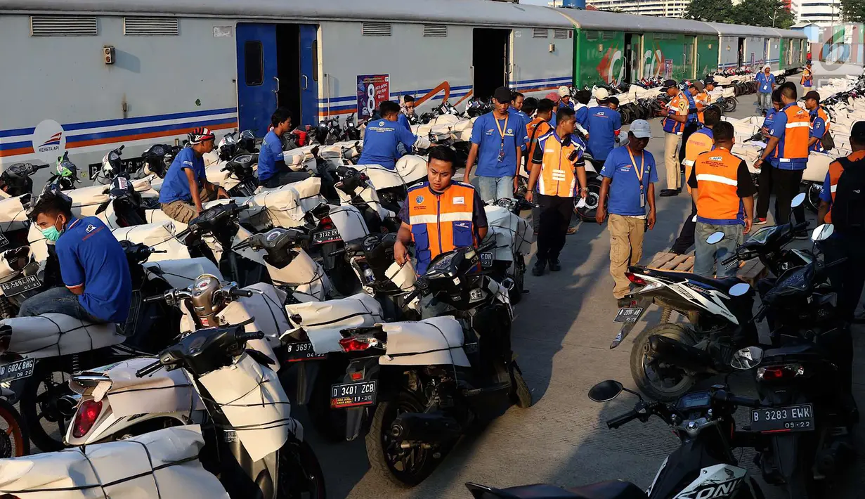 Petugas mengemas sepeda motor untuk diangkut dengan kereta api Stasiun Kampung Bandan, Jakarta, Senin (11/6). Program mudik gratis ini digagas Kemenhub tersebut melayani pengiriman ke beberapa daerah di Pulau Jawa. (Liputan6.com/Immanuel Antonius)