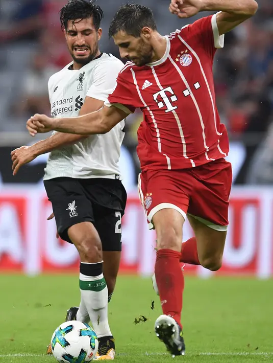 Gelandang Liverpool, Emre Can (kiri) berebut bola dengan gelandang Munchen, Javi Martinez saat bertanding di semifinal Audi Cup di Allianz Arena di Munich, Jerman (1/8). Liverpool menang 3-0 atas Munchen. (Christof Stache/AFP)