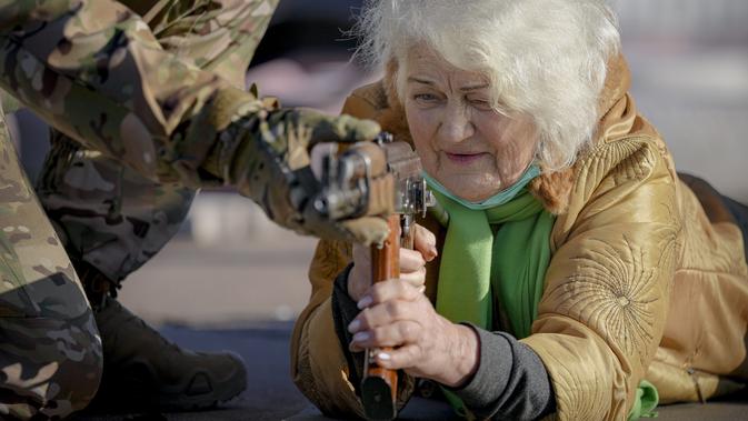Valentyna Konstantynovska (79) memegang senjata saat latihan perang dasar untuk warga sipil oleh Unit Pasukan Khusus Azov, dari Garda Nasional Ukraina, di Mariupol, Donetsk, Minggu (13/2/2022). Mereka disiapkan untuk bisa bertahan di tengah kekhawatiran akan invasi Rusia. (AP Photo/Vadim Ghirda)