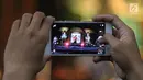 Penonton mengambil gambar dengan ponsel saat menonton Seri Konser Situs Budaya Iwan Fals dan Band di Panggung Kita, Depok, Sabtu (3/3). Konser Situs Budaya ini mengangkat budaya dari NTB Kerajaan Lombok dan Bima. (Liputan6.com/Arya Manggala)