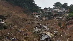 Helikopter tim penyelamat pemadam kebakaran melintasi area tanah longsor untuk mencari korban selamat di Petropolis, Brasil, 16 Februari 2022. Banjir skala besar menghancurkan ratusan properti dan merenggut sebanyak 34 nyawa di daerah tersebut. (CARL DE SOUZA/AFP)