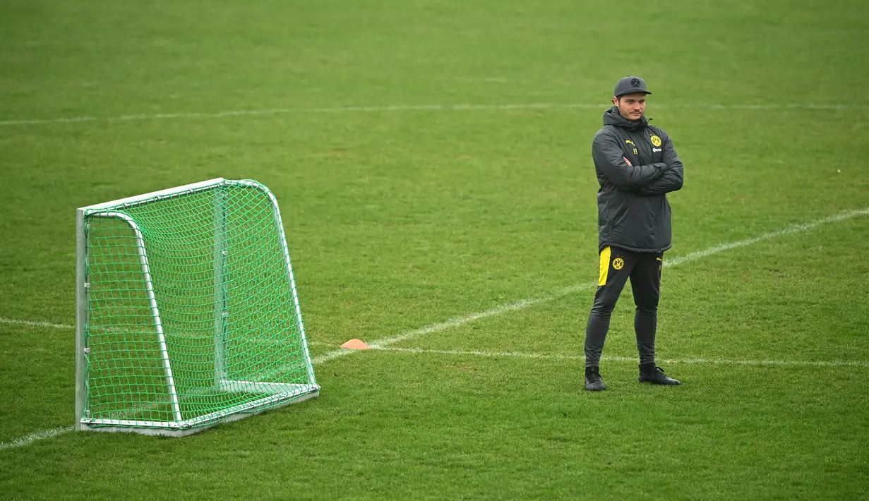 Pelatih Borrusia Dortmund, Edin Terzic menyaksikan pemainnya berlatih di tempat latihan tim di Dortmund, Jerman barat (9/3/2021). Dortmund sebelumnya berhasil mengalahkan Sevilla dengan skor 3-2 di leg pertama. (AFP/Ina Fassbender)