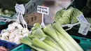 Sebuah tanda menampilkan harga barang-barang sayuran di kios pasar di Walthamstow Market di London timur, Minggu (22/11/2021). Inflasi Inggris telah mencapai level tertinggi 10 tahun karena tagihan energi rumah tangga meroket, menurut data minggu lalu. (Tolga Akmen/AFP)