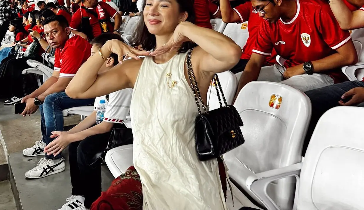 Ibu empat anak itu memadukan atasan halterneck asimetris dengan kain merah yang dijadikan sarung [@jenniferbachdim]