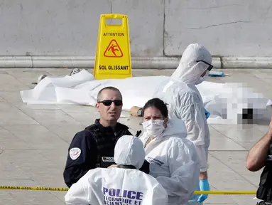 Petugas berjaga di dekat korban penyerangan di luar stasiun kereta api Saint Charles, di Marseille, Prancis Selatan, (1/10). Dua orang tewas dalam sebuah serangan pisau yang dilakukan seorang pria di stasiun tersebut. (AP Photo/Claude Paris)