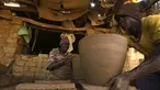 Seorang perajin Sudan membentuk sepotong tembikar di sebuah bengkel di Omdourman, di pinggiran barat ibu kota Khartoum (19/1/2022). Pot tanah liat tersebut nantinya akan dipajang untuk dijual. (AFP/Ashraf Shazly)