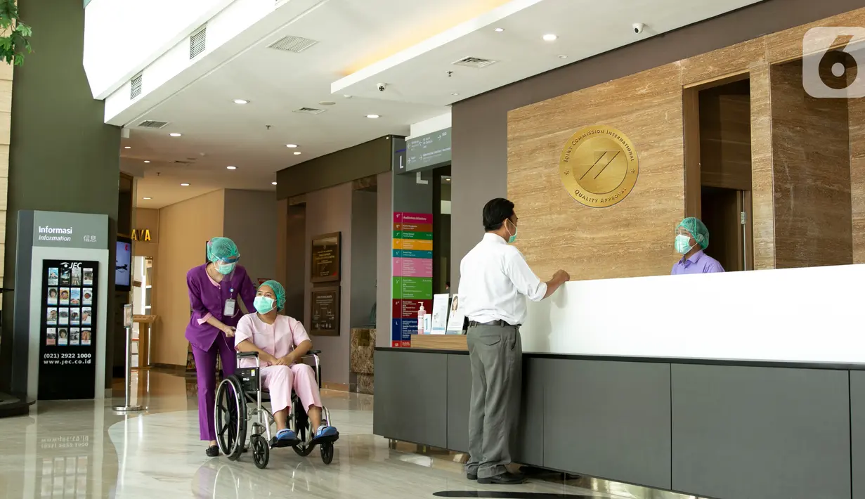 Perawat membantu pasien mata mendorong kursi roda di JEC Eye Hospitals and Clinics, Kedoya, Jakarta, Kamis (17/09/2020). Rumah sakit mata peraih Akreditasi Gold Seal dari JCI meningkatkan kualitas kesehatan dan keselamatan pasien guna menekan penyebaran Covid-19. (Liputan6.com/Pool)