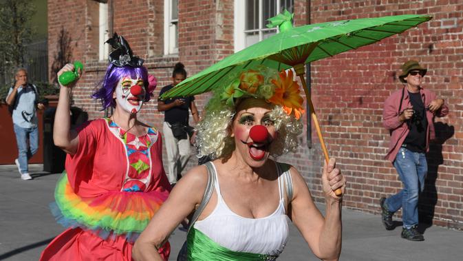 Para peserta berkostum badut berlarian selama acara 'Running of the Clowns' di Pasadena, California pada 21 Oktober 2018. Lari dikejar kawanan badut ini merupakan parodi yang mengolok-olok lomba dikejar banteng di Pamplona, Spanyol. (Mark RALSTON/AFP)