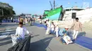 Anak-anak memunguti koran bekas usai pelaksanaan salat Idul Fitri di kawasan Pelabuhan Sunda Kelapa, Jakarta, Rabu (5/6/2019). Umat muslim seluruh Indonesia merayakan Hari Raya Idul Fitri 1440 Hijriah setelah sebelumnya melaksanakan puasa Ramadan selama sebulan penuh. (merdeka.com/Arie Basuki)