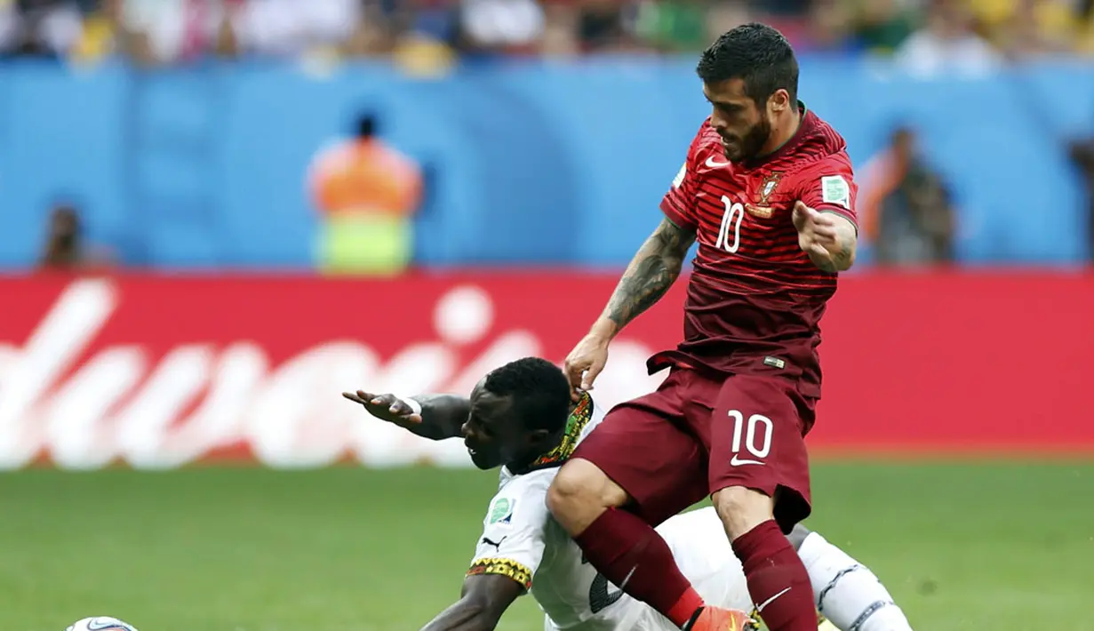 Gelandang Timnas Ghana, Kwadwo Asamoah (kiri) terjatuh akibat tackling pemain tengah Portugal, Vieirinha, di laga penutup penyisihan Piala Dunia 2014 Grup G di Stadion Nasional Brasilia, (26/6/2014). (REUTERS/Ueslei Marcelino)