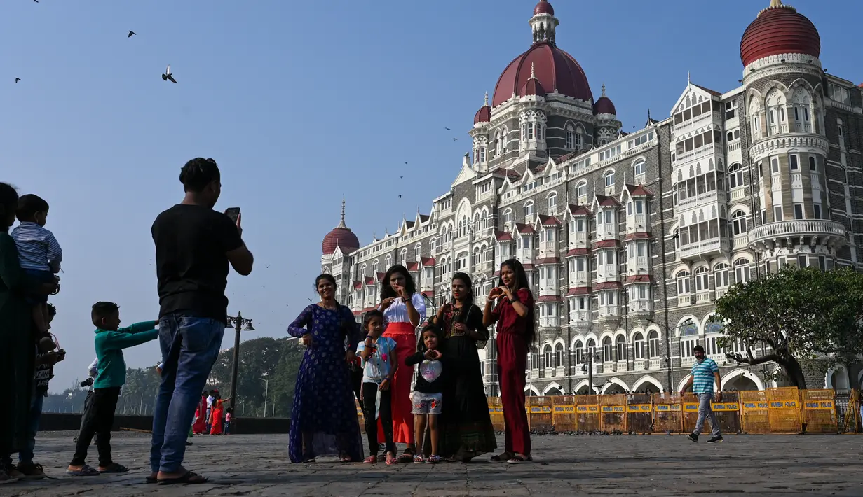 Turis berkunjung di dekat hotel Taj Mahal Palace, salah satu lokasi serangan teroris 2008, di Mumbai (26/11/2021). (AFP/Punit Paranjpe)