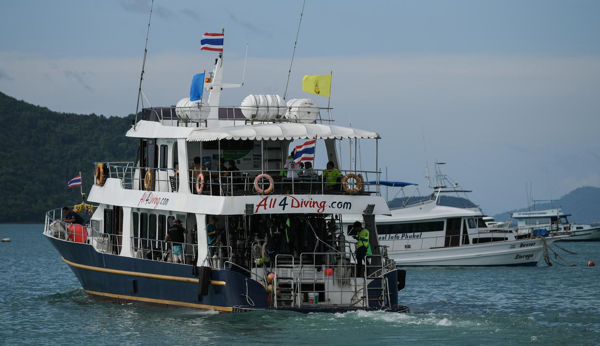 Sebuah kapal membawa para penyelam meninggalkan dermaga Chalong untuk melanjutkan pencarian kapal wisata yang terbalik di Phuket, Sabtu (7/7). Insiden ini merupakan salah satu kecelakaan kapal terparah dalam sejarah Thailand. (AFP/Mohd RASFAN)