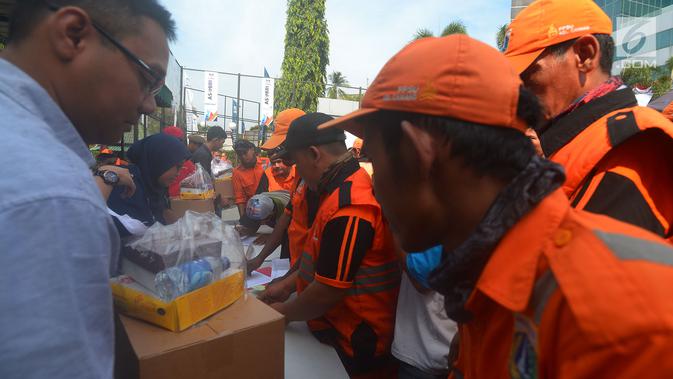 Petugas Penangganan Prasarana dan Saran Umum (PSSU) atau pasukan oranye mendapatkan sembako gratis di Jakarta, Jumat (3/8). Pembagian sembako gratis tersebut dalam rangka menyambut HUT ASABRI ke-47 tahun. (Merdeka.com/Imam Buhori)