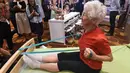 Pesenam tertua di dunia asal Jerman, Johanna Quaas (92) menunjukkan latihan penguatan di tempat tidur khusus untuk orang tua saat Forum Inovasi Aging Asia Internasional ke-8 di Singapura, Selasa (25/4). (AFP PHOTO / ROSLAN RAHMAN)