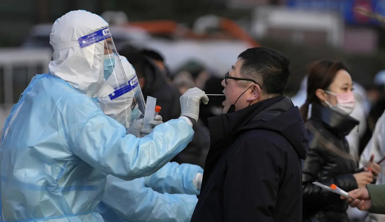 Seorang pria mendapatkan usap tenggorokan untuk tes COVID-19 di fasilitas pengujian virus corona seluler di Beijing, Senin (17/1/2022). Beijing telah melaporkan infeksi omicron lokal pertamanya, beberapa minggu sebelum Olimpiade Musim Dingin akan dimulai. (AP Photo/Andy Wong)