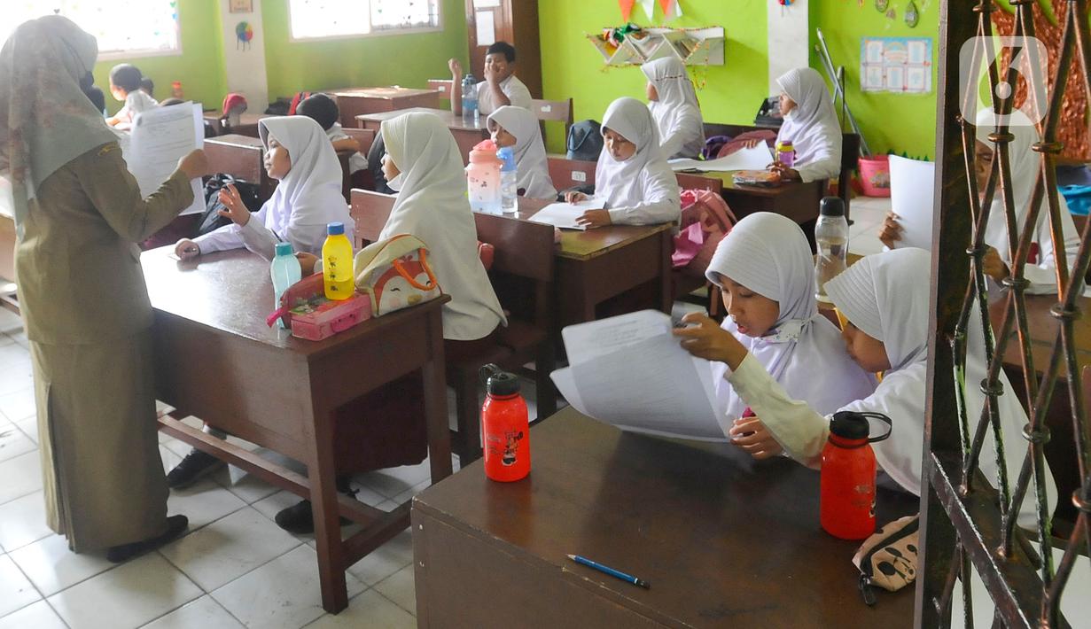 Siswa mengikuti ujian penilaian akhir semester (PAS) yang dihadiri guru pengawas di SDN Pondok Cina 1 Depok, Jawa Barat, Senin (5/12/2022). Guru SDN Pondokcina 1 Depok kembali hadir di sekolah itu pada hari ini. (merdeka.com/Arie Basuki)