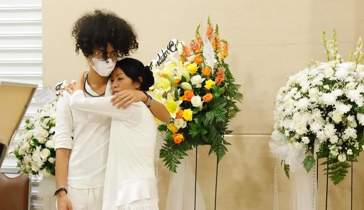 Dee Lestari tidak jaim di depan anak kala menanggung duka dan berupaya melewati masa perkabungan. Sejumlah foto memperlihatkan mantan personel Rida Sita Dewi memeluk erat anaknya. Begitulah cara keluarga berbagi beban. “Dengan demikian, kami bisa berbagi beban ini. Sha, Nan, hidup Mama kini sepenuhnya untuk kalian,” penulis novel Perahu Kertas menyambung. (Foto: Dok. Hanafi dari Instagram @deelestari)