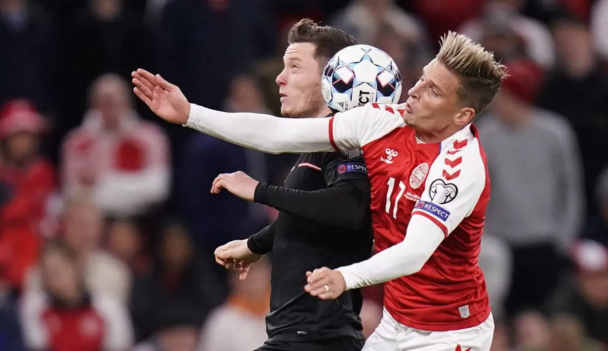 Pemain Austria Michael Gregoritsch (kiri) bersaing memperebutkan bola dengan pemain Denmark Jens Stryger Larsen pada pertandingan Grup F kualifikasi Piala Dunia 2022 di Kopenhagen, Denmark, Selasa (12/10/2021). Denmark menang 1-0. (Liselotte Sabroe/Ritzau Scanpix/AFP)