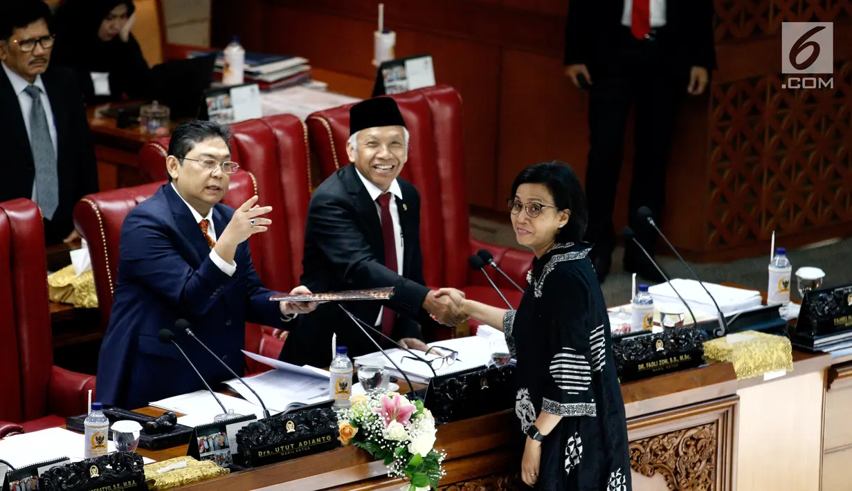 Menkeu Sri Mulyani  bersalaman dengan Wakil Ketua DPR Agus Hermanto saat Rapat Paripurna di Jakarta, Kamis (4/7/2019). Rapat membahas berbagai agenda salah satunya Penyampaian RUU tentang Penanggungjawaban atas Pelaksanaan RAPBN (P2APBN) TA 2018 Pemerintah. (Liputan6.com/Johan Tallo)