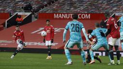 Tendangan bebas pemain Manchester United, Bruno Fernandes (kiri) berhasil menjebol gawang Liverpool pada laga babak keempat FA Cup 2020-21 di Old Trafford, Senin (25/01/2021). (Foto: AP/Pool/Phil Noble)