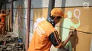 Petugas PPSU membuat mural bertema Asian Games di kawasan Cawang, Jakarta, Selasa (17/7). Mural tersebut dibuat untuk sosialisasi sekaligus bentuk dukungan terhadap perhelatan Asian Games pada Agustus 2018 mendatang. (Liputan6.com/Faizal Fanani)