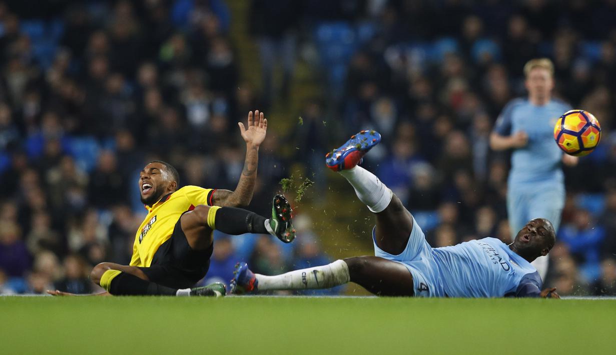 Pemain Watford, Jerome Sinclair, dan pemain Manchester City, Yaya Toure, sama-sama terjatuh saat berebut bola Watford dalam laga pekan ke-16 Premier League 2016-2017 di Stadion Etihad, Rabu (14/12/2015) waktu setempat. (Reuters/Phil Noble)