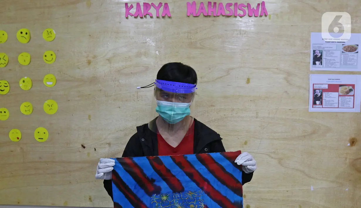 Mahasiswa inklusif atau berkebutuhan khusus Auzan menunjukkan hasil karya membatik seusai melakukan kegiatan membatik di lembaga pendidikan dan keterampilan "Kampusnya Manusia" kawasan Jatisampurna, Bekasi, Jawa Barat, Kamis (13/8/2020). (Liputan6.com/Herman Zakharia)