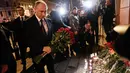 Presiden Rusia, Vladimir Putin membawa karangan bunga di dekat lokasi ledakan bom di stasiun kereta bawah tanah di St. Petersburg, Senin (3/4). Putin memberi penghormatan kepada para korban ledakan yang terjadi di lokasi itu. (AP Photo/Dmitri Lovetsky)