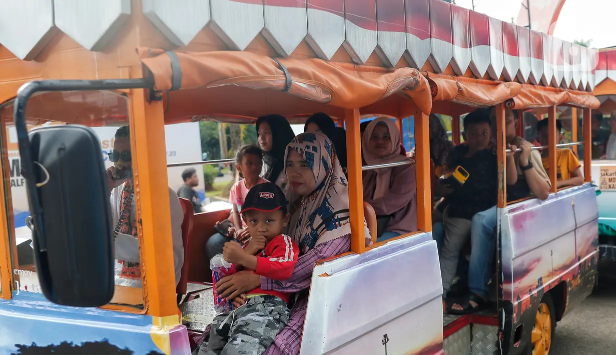 Pengunjung menaiki kereta mobil saat menikmati liburan Idul Adha 2023. (Liputan6.com/Angga Yuniar)