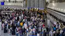 Penumpang mengantri di konter check-in di bandara internasional di Frankfurt, Jerman, Rabu (27/7/2022). Maskapai Jerman, Lufthansa telah membatalkan lebih dari 1.000 penerbangan. Pembatalan dilakukan imbas dari mogok kerja seluruh staf daratnya. (AP Photo/Michael Probst)