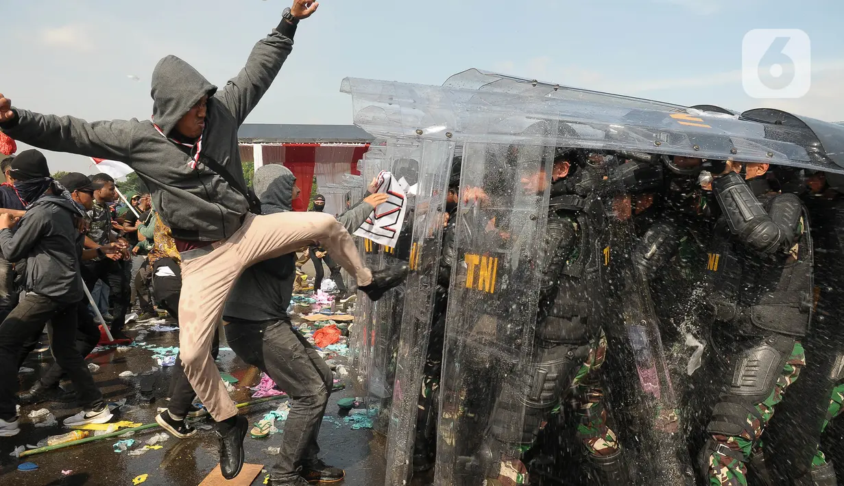 Tentara Nasional Indonesia (TNI) melakukan simulasi demonstrasi pengerahan massa yang anarkis pada Apel Pengamanan Pemilu 2024 di Lapangan Halim Perdanakusuma, Jakarta, Kamis (1/2/2024). (merdeka.com/Imam Buhori)