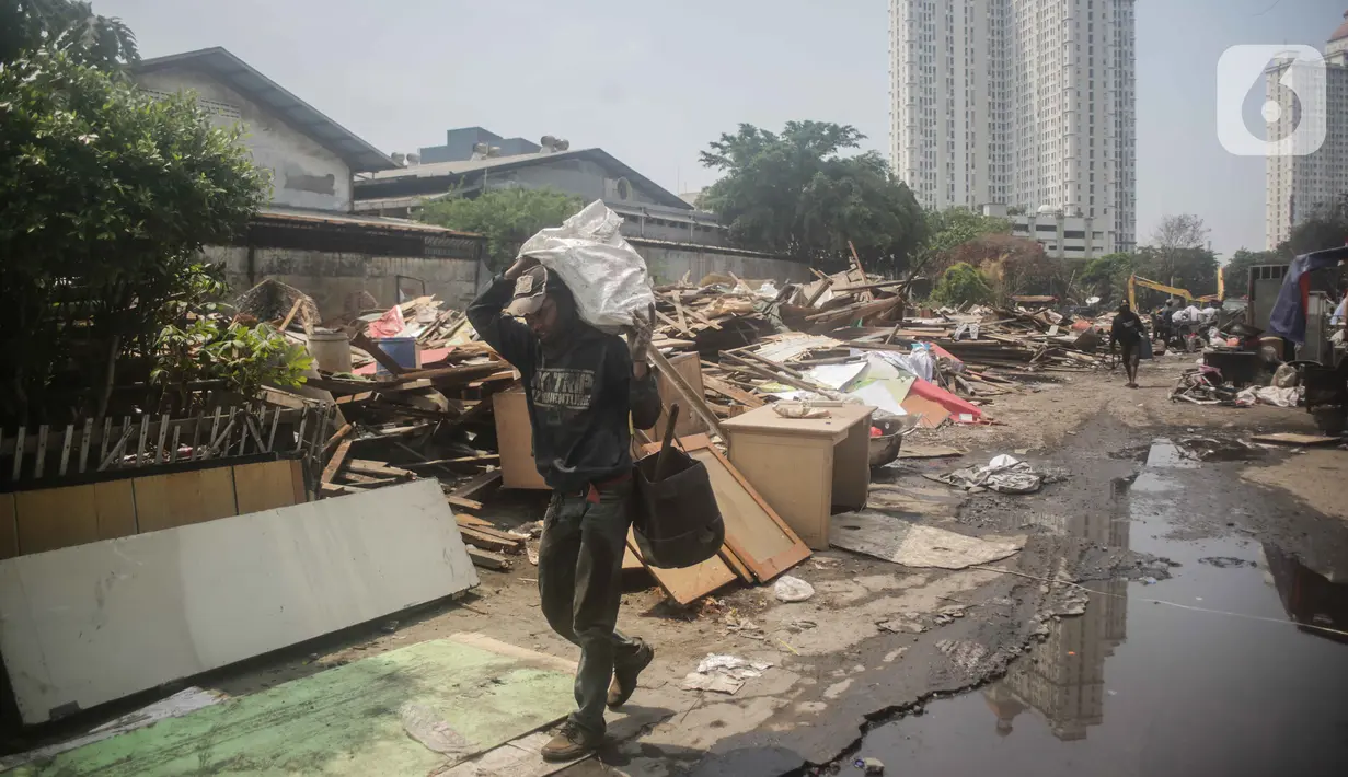 Warga membawa barang miliknya saat pembongkaran bangunan liar di dekat kali kecil di kawasan Jalan Agung Perkasa VIII Sunter, Jakarta, Senin (18/11/2019). Pembongkaran untuk mengembalikan fungsi saluran air kawasan agar tidak menimbulkan banjir saat musim penghujan tiba. (Liputan6.com/Faizal Fanani)