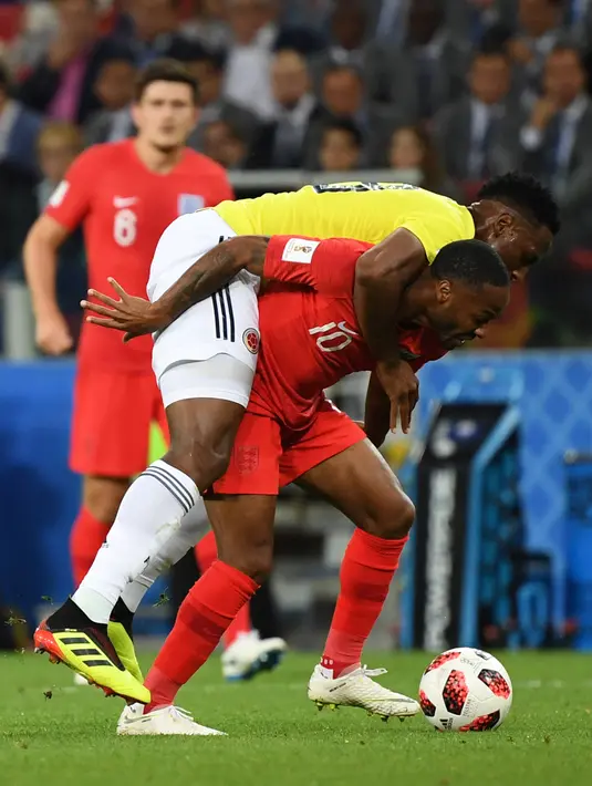 Pemain timnas Inggris, Raheem Sterling berebut bola dengan bek Kolombia, Yerry Mina pada babak 16 besar Piala Dunia 2018 di Stadion Spartak, Selasa (3/7). Sterling menjadi bahan pembicaraan setelah tertangkap kamera menggendong Mina (AFP/YURI CORTEZ)