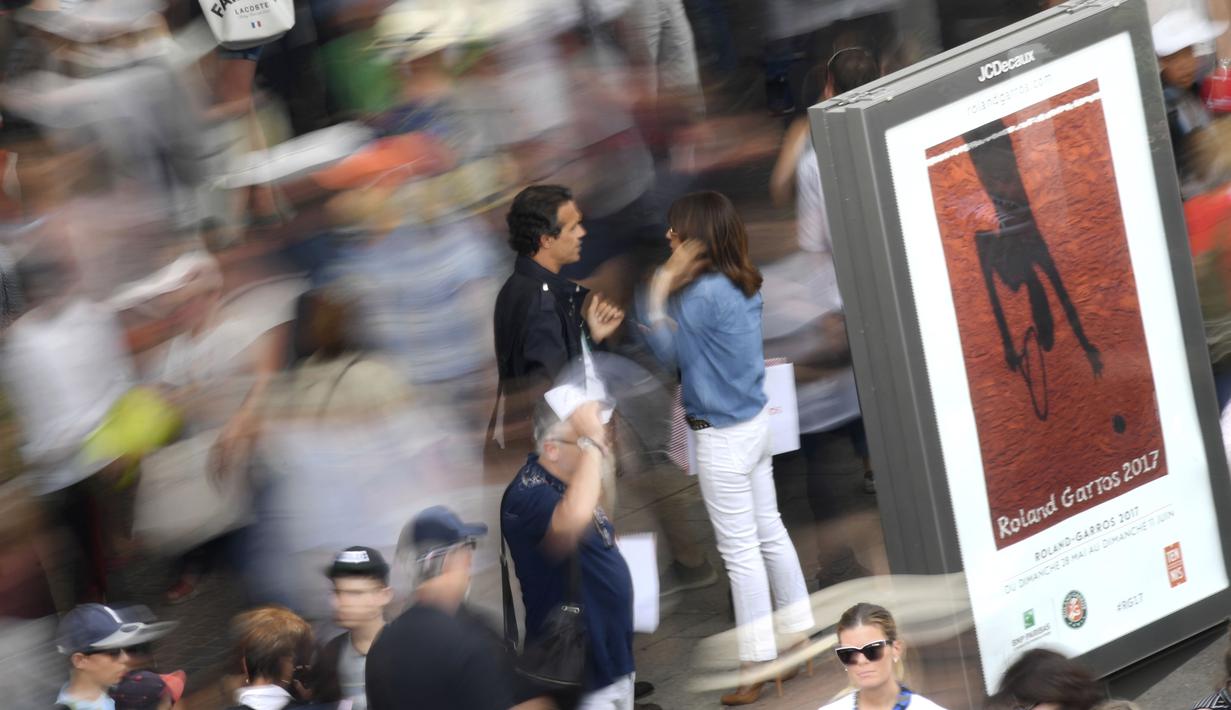 Suasana penonton saat melewati poster laga tenis di Roland Garros 2017,  Prancis Terbuka, Paris, (30/5/2017). (AFP/Gabriel Bouys)