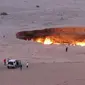 Sebuah gambar yang diambil pada 3 Mei 2014, menunjukkan orang-orang mengunjungi "The Gateway to Hell," sebuah kawah gas besar yang terbakar di jantung gurun Karakum, Turkmenistan. (AFP)