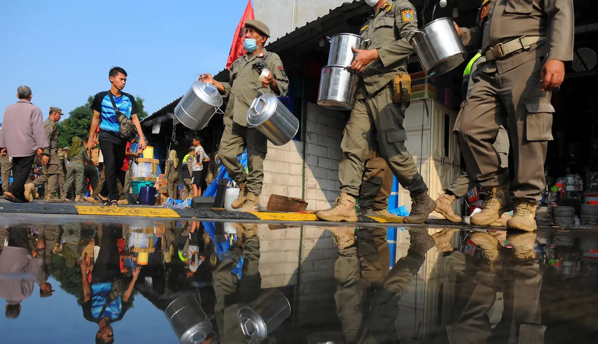 Petugas Satpol PP mengeluarkan barang milik pedagang saat penertiban di Pasar Perabot Rumah Tangga di Jatinegara, Jakarta, Rabu (21/6/2023). (merdeka.com/Imam Buhori)