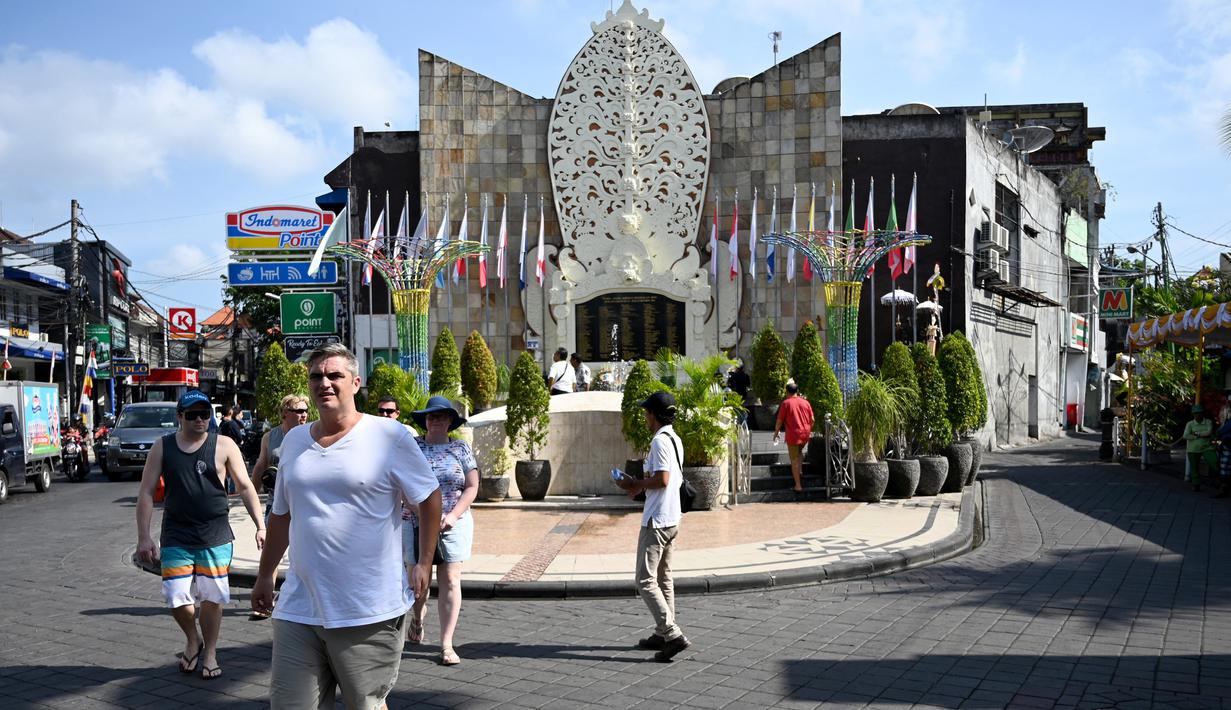 Turis asing mengunjungi Monumen Bom Bali di Kuta, dekat Denpasar pada Sabtu (12/10/2019). MeMperingati 18 tahun peristiwa bom Bali yang terjadi pada 12 Oktober 2002, wisatawan dan kerabat korban mengunjungi tugu peringatan untuk berdoa dan tabur bunga. (SONNY TUMBELAKA / AFP)
