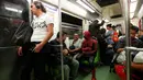 Moises Vazquez berbincang dengan penumpang kereta menuju Universitas Otonomi Nasional Meksiko (UNAM) di Meksiko City, Meksiko, 27 Mei 2016. Pria 26 tahun ini sering kali menggunakan kostum spiderman ketika pergi mengajar. (REUTERS/Edgard Garrido)