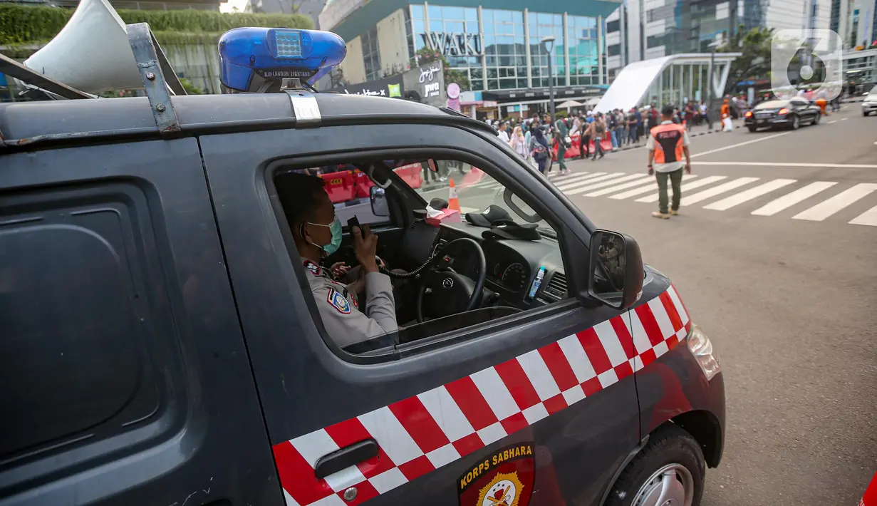 Personel gabungan mengatur lalu lintas saat mobil polisi melakukan patroli di kawasan zebra cross Dukuh Atas, Jakarta, Rabu (27/7/2022). Mereka dikerahkan untuk memantau kegiatan peragaan busana Citayam Fashion Week (CFW) guna meminimalisir terjadinya kriminalitas, kemacetan, hingga parkir liar. (Liputan6.com/Faizal Fanani)