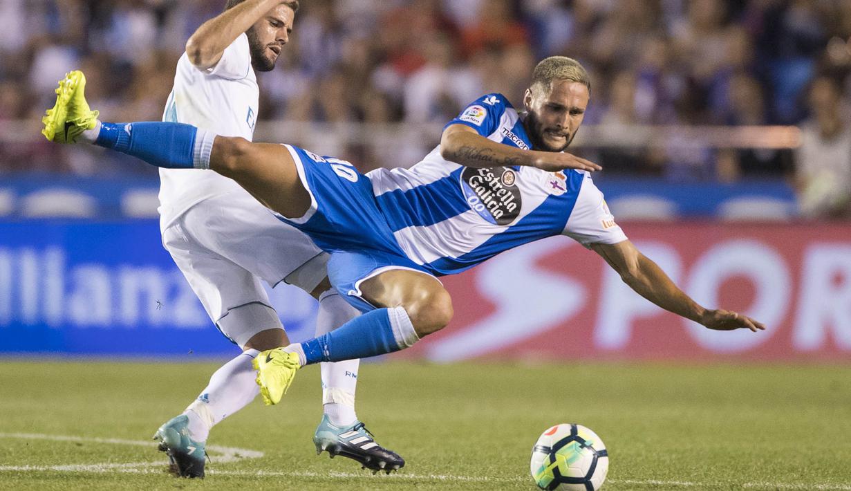 Striker Deportivo La Coruna, Florin Andone, terjatuh saat berebut bola dengan bek Real Madrid, Nacho, pada laga La Liga di Stadion Riazor, Senin (21/8/2017). Real Madrid menang 3-0 atas Deportivo La Coruna. (AP/Lalo R. Villar)