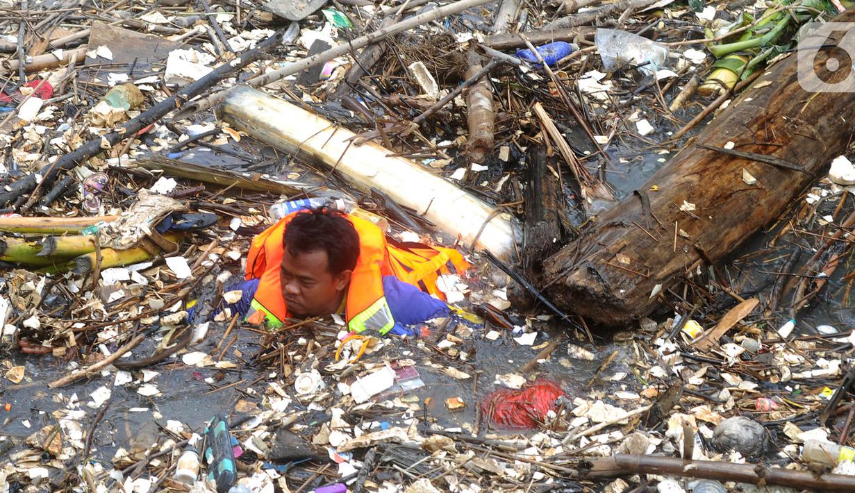 Petugas gabungan membersihkan tumpukan sampah yang menyumbat aliran air Sungai Cikeas di kawasan Bendung Koja Jatiasih, Bekasi, Jawa Barat, Rabu (16/10/2019). Pembersihan sekitar 1.200 meter kubik sampah bambu tersebut diperkirakan menghabiskan waktu dua minggu. (merdeka.com/Arie Basuki)