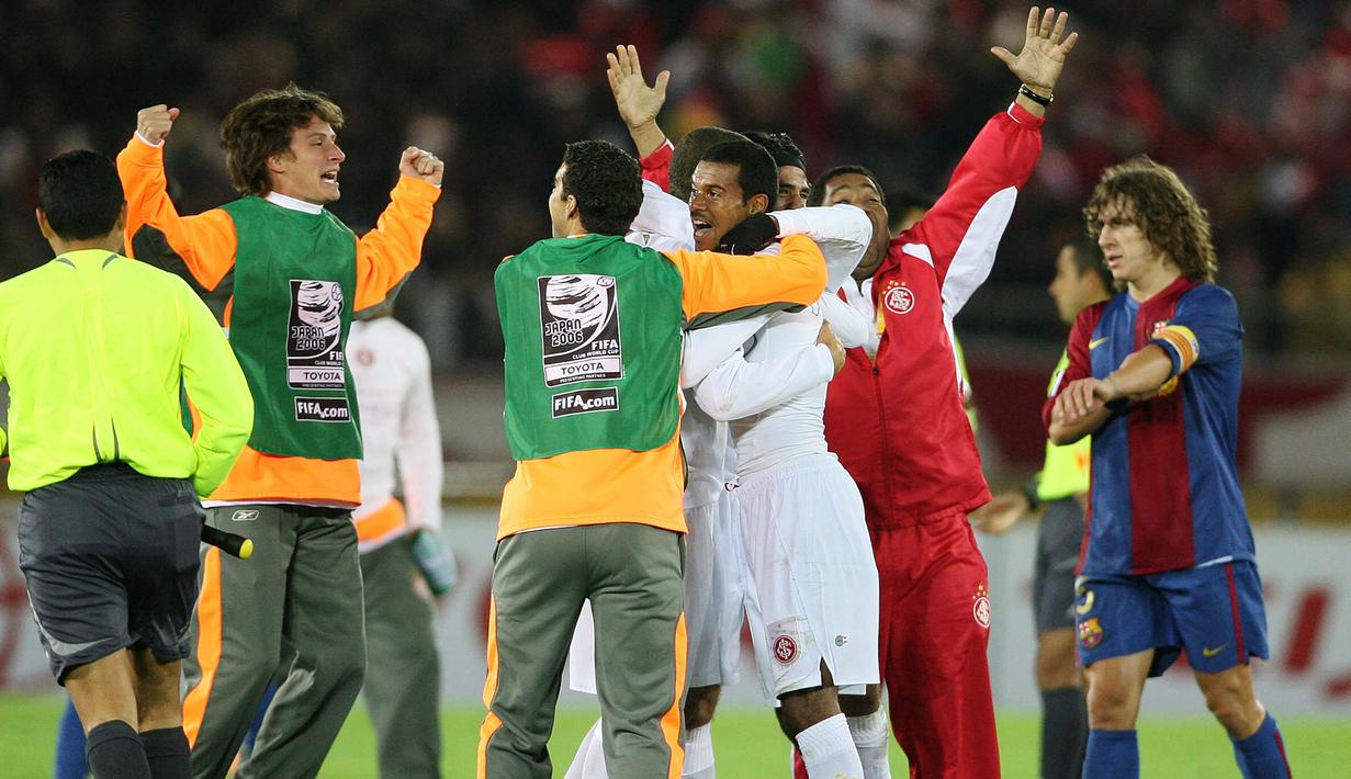 Kapten tim Barcelona, Carles Puyol (kanan) berjalan meninggalkan lapangan setelah ditaklukkan Internacional dalam laga final Piala Dunia Antar-klub 2006 di Yokohama Stadium, Jepang (17/12/2006). Barcelona yang berstatus juara Liga Champions 2005/2006 langsung berlaga di babak semifinal Piala Dunia Antar-klub 2006. Lolos ke final setelah menang 4-0 atas Club America, Barcelona akhirnya takluk 0-1 dari Internacional. (AFP/Toru Yamanaka)