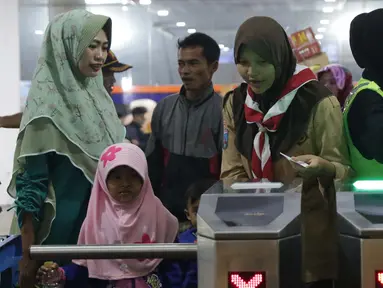 Anggota Pramuka membantu calon penumpang melakukan cek in elektronik di ruang tunggu menuju dermaga Pelabuhan Penyeberangan Merak, Banten, Sabtu (1/6/2019). Hingga Sabtu (1/6) pukul 08.00 WIB, tercatat 400.309 orang menyebrang dari pelabuhan Merak menuju Bakauheni. (Liputan6.com/Helmi Fithriansyah)