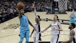 Pemain Charlotte Hornets, Malik Monk (1) mencetak skor saat melewati adangan para pemain San Antonio pada laga NBA basketball game di AT&T Center, San Antonio, (3/11/2017) waktu setempat. San Antonio menang 108-101. (AP/Eric Gay)